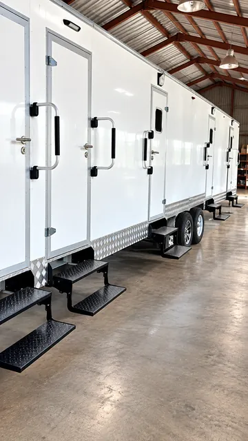 Combination shower-restroom trailer in a warehouse