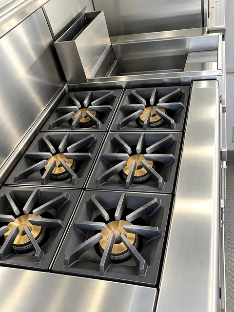 Commercial gas range beneath an exhaust hood