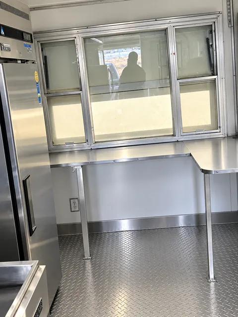 Stainless prep counter beneath a service window