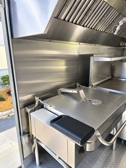 Tilt skillet beneath an exhaust hood
