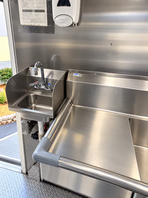 Stainless prep table beside a wash sink