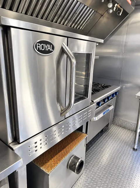 Commercial cooking equipment beneath an exhaust hood
