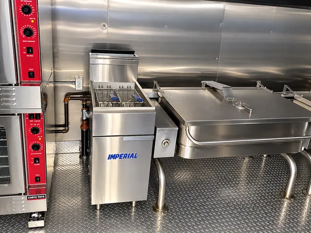 Deep fryer and tilt skillet beside commercial ovens