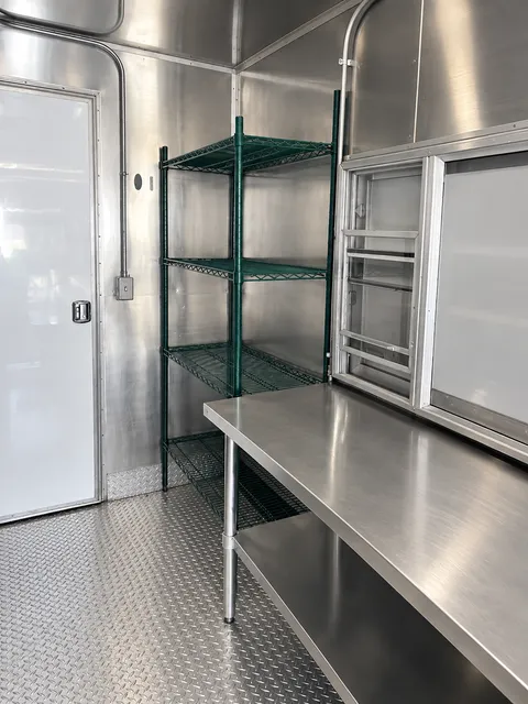 Stainless prep table beside storage shelving