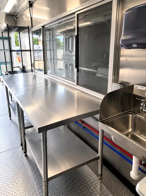 Stainless prep table beneath a service window